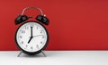 Black alarm clock on a red background