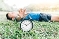 Black alarm clock and sleeping boy in the park Royalty Free Stock Photo