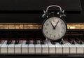Black alarm clock stand on the Piano Keyboard Royalty Free Stock Photo