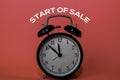 Black Alarm Clock and Start Of Sale write on pink background Royalty Free Stock Photo
