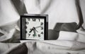 Black alarm clock on a white sheet with hard shadows Royalty Free Stock Photo