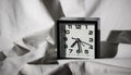 Black alarm clock on a white sheet with hard shadows Royalty Free Stock Photo