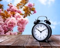 Black alarm clock on wooden table, space for text. Daylight saving time Spring forward Royalty Free Stock Photo