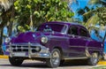 Black american Oldtimer parked under palms near the beach in Varadero Cuba - Serie Cuba 2016 Reportage Royalty Free Stock Photo