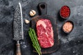 Black angus ribeye, raw rib-eye beef steak on a wooden board with knife. Black background. Top view Royalty Free Stock Photo