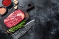 Black angus ribeye, raw rib-eye beef steak on a wooden board with knife. Black background. Top view. Copy space Royalty Free Stock Photo