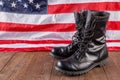 black ankle boots in front of US flag on wooden surface
