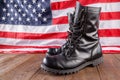 black ankle boots in front of US flag on wooden surface