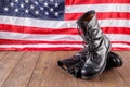 Black ankle boots in front of US flag on wooden surface