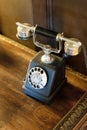 Black antique analog telephone on wooden table