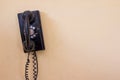 Black antique vintage analog telephone dialing or scrolling phone on old wall. Royalty Free Stock Photo