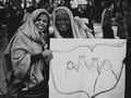 Black and arabic women holding poster