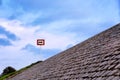 Black arrow on white background and in red frame standing atop of cobblestone paved hill at day. Blue sky with great