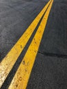 Black asphalt with reflective yellow solid stripes