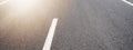 Black asphalt road and with white dividing lines, illuminated by the sun - Street texture background banner panorama Royalty Free Stock Photo