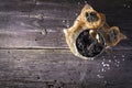 Black Astrakhan Russian salted sturgeon caviar in a can on dark background with wooden spoon and slices of bread