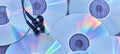 Black audio headphones on a pile of glossy compact discs with colored reflections Royalty Free Stock Photo