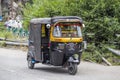 Black auto rickshaw taxis on a road in Srinagar, Kashmir, India