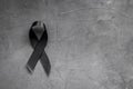 Black awareness ribbon on dark background. Mourning symbol