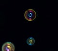 On a black background are colored soap bubbles and an abstract colored pattern Royalty Free Stock Photo