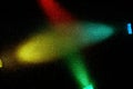 On a black background, cross beams of light blue red green and yellow gradient light Royalty Free Stock Photo