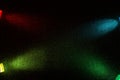 On a black background in fine grain cross oncoming short rays of blue red green and yellow gradient light Royalty Free Stock Photo