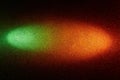 On a black background, a gradient green and orange beam of light