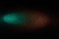 On a black background, a gradient turquoise and brown beam of light