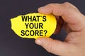 On a black background, in the hands of a man, a yellow torn cardboard with the inscription - Whats Your Score Royalty Free Stock Photo