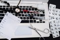 white laptop on which a stethoscope, pills, syringe, thermometer and a side notebook with a pen Royalty Free Stock Photo