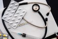 white laptop on which a stethoscope, pills, syringe, thermometer and a side notebook with a pen Royalty Free Stock Photo