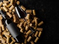 On a black background a lot of wine corks, a bottle of red wine and a wine glass. Romantic date, holiday, banquet, restaurant, Royalty Free Stock Photo