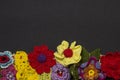 Black background and multicolored knitted flowers from below Royalty Free Stock Photo