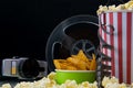 Black background, old video camera, popcorn, film, at the bar on the table Royalty Free Stock Photo