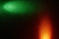 On a black background, perpendicular green and orange rays of light Royalty Free Stock Photo