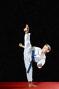 On a black background and red mat the boy beat blow leg mawashi geri
