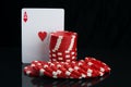 On a black background with reflection, close-up of the highest card and red chips,for playing poker, with space for inscription Royalty Free Stock Photo