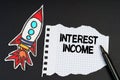 On a black background, a rocket, a marker and paper with the inscription - Interest Income Royalty Free Stock Photo