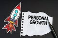 On a black background, a rocket, a marker and paper with the inscription - PERSONAL GROWTH Royalty Free Stock Photo