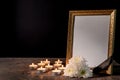 Blank funeral frame, candles and flowers on table against black background Royalty Free Stock Photo