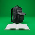 A black backpack with multiple compartments and zippers stands upright on a bright Royalty Free Stock Photo