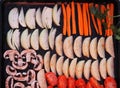 Black baking tray from a home oven with sliced vegetables for baking or drying.Homemade cooking with chips and baked vegetables.