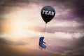 A black balloon that says FEAR carries an airplane chair demonstrating feelings of fight or flight anxiety concept . 3D. Royalty Free Stock Photo