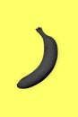 Black banana on a yellow background. Surrealistic Minimalist Art