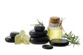 Black basalt stones for hot massage with an oil bottle, rosemary and orchid flower isolated on white