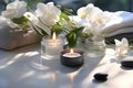 Black basalt stones for spa treatments with white small candles on a white towel. Playground AI platform Royalty Free Stock Photo