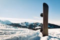 Black base snowboard in a snow with white mountains in the background. Concept of end beginning of ski season.Goderdzi ski resort Royalty Free Stock Photo