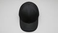 Black baseball cap on gray background with stitch detail and ventilation eyelets Royalty Free Stock Photo