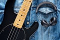 Black bass guitar and headphones on vintage denim jeans jacket Royalty Free Stock Photo