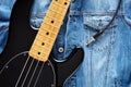 Black bass guitar with jack cable on vintage denim jeans jacket for music background Royalty Free Stock Photo